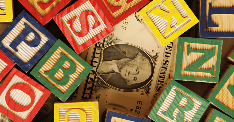 Image of building block over dollar bill